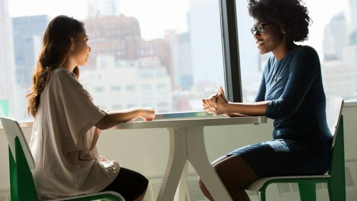 Twee professionals in gesprek aan tafel
